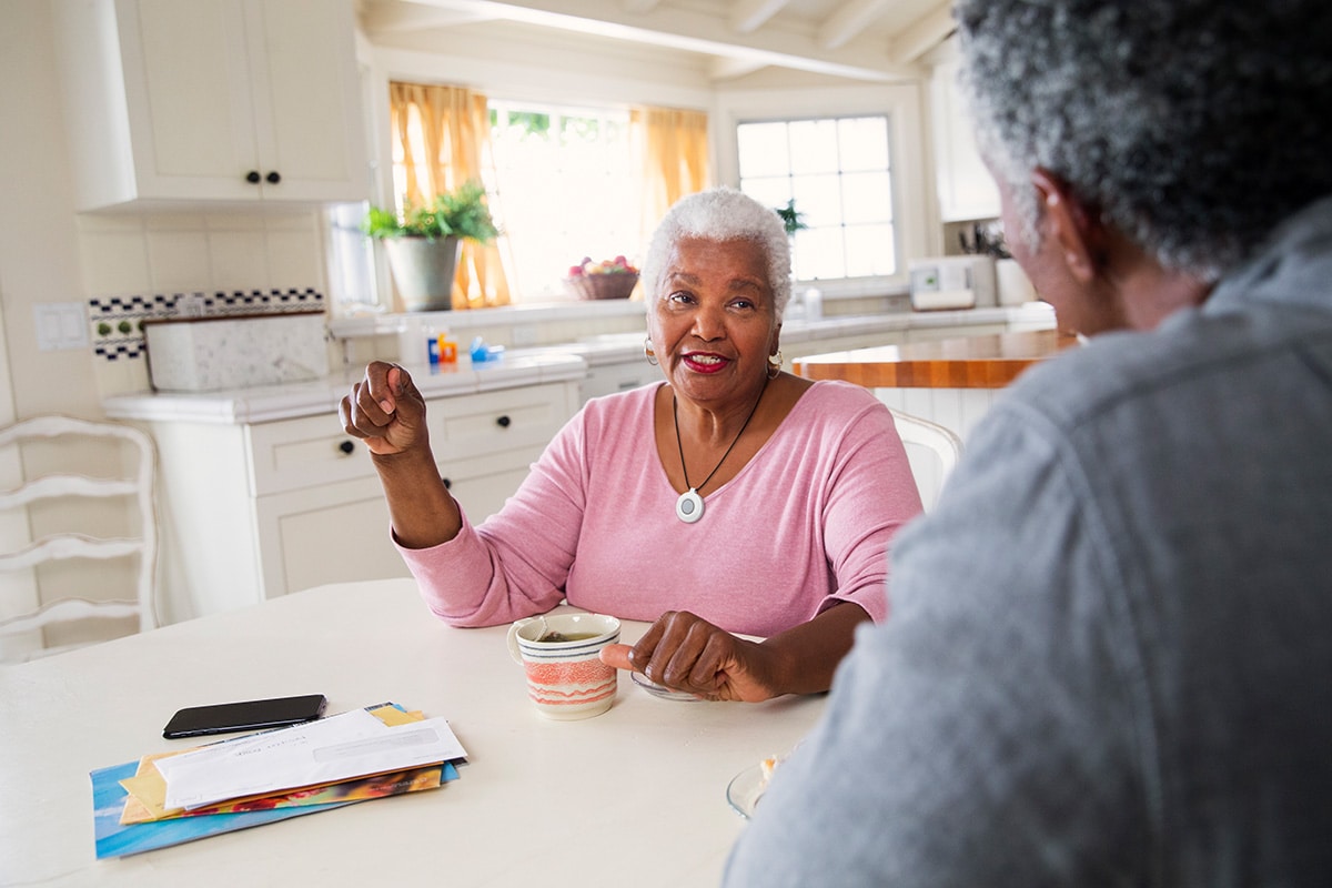 Woman wearing HomeSafe medical alert system talking to husband