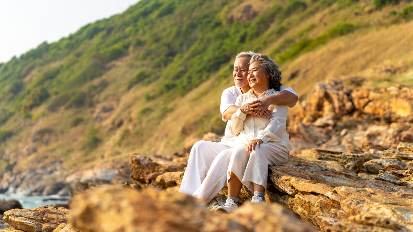 Man and woman sitting on a cliff in nature