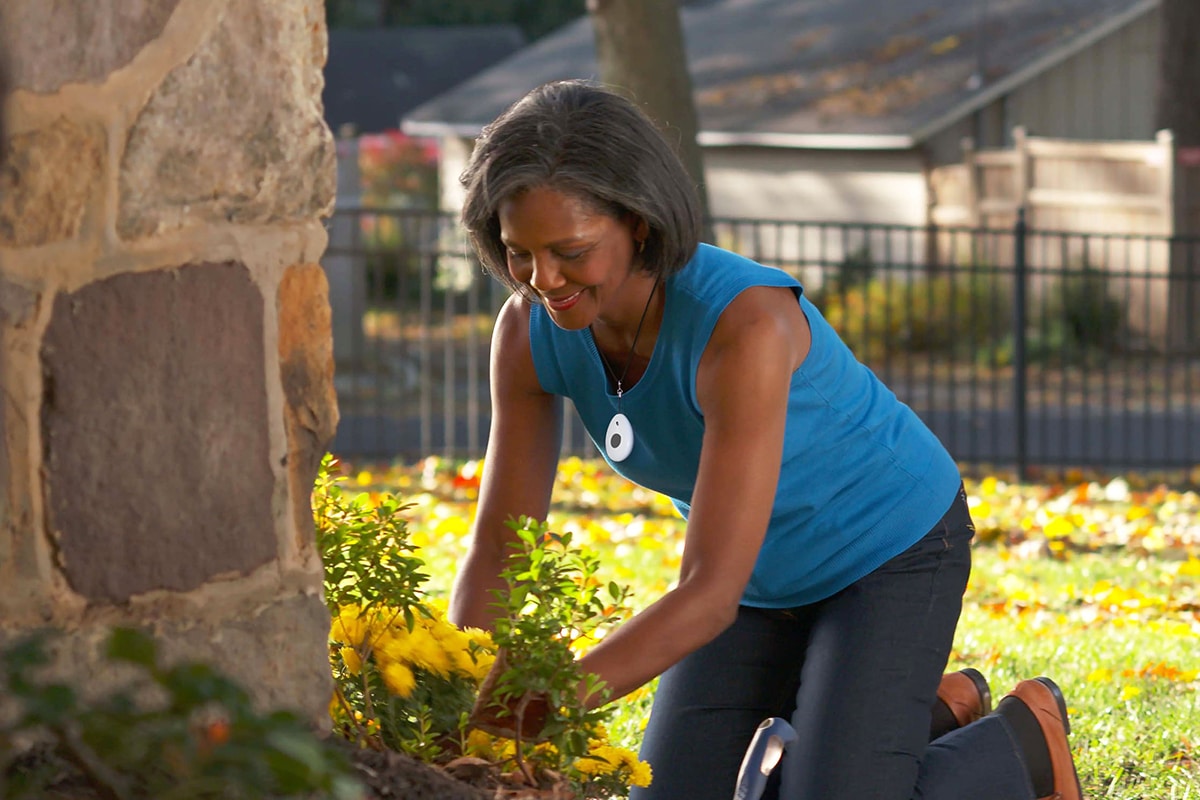 Woman Gardening Wearing Automatic Fall Detection Pendant